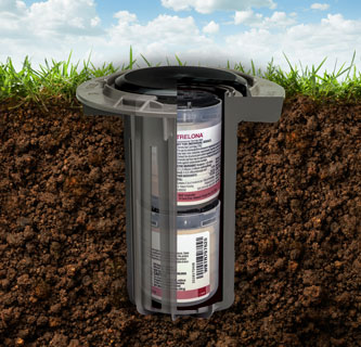 Photo showing a cut away of the ground with a Trelona ATBS termite bait station installed into it.